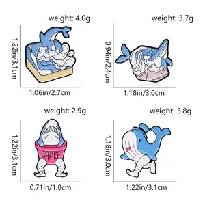 Set mit vier Emaille-Pins mit Meerestieren wie Delfinen und laufenden Walen
