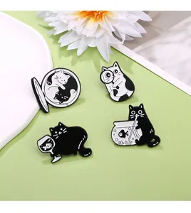 Vue détaillée de quatre épingles en émail de chat noir et blanc sur un fond vert pastel