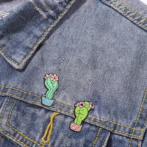 Zwei lustige Kaktus-Emaille-Pins an einer klassischen blauen Jeansjacke als Dekoration