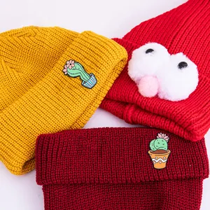 Drei bunte Strickmützen mit süßen Kaktus-Stickereien und flauschigen Bommel-Dekorationen