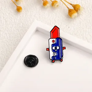 Close-up of a cartoon lipstick enamel pin with red tip and black rubber clutch backing