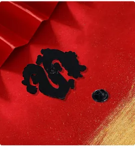 Detail der Drachen-Emaille-Anstecknadel mit schwarzem Schmetterlingsverschluss auf Rot
