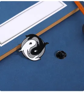 Detailed view of the Tai Chi Yin Yang koi enamel brooch with its black rubber clutch back