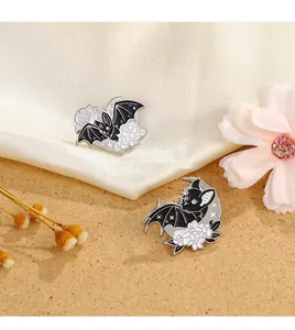 Détail des broches chauve-souris en émail avec cœur et croissant sur fond de soie