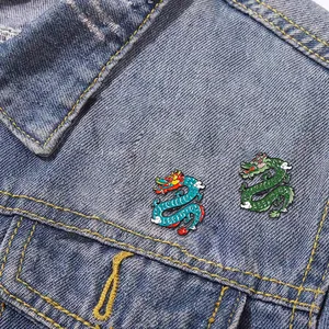 Niedliche chinesische Drachen-Emaille-Pins in Blau und Grün auf einer Jeansjacke