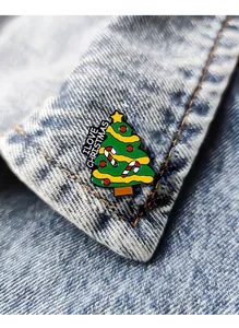 Close-up of enamel Christmas tree pin with I LOVE CHRISTMAS text on denim jacket