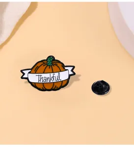 Detail view of pumpkin enamel pin with Thankful ribbon and black rubber clutch backing