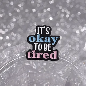 Detailansicht der Emaille-Anstecknadel mit Spruch 'IT'S okay TO BE tired' und Herz-Detail