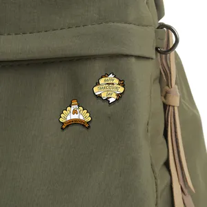 Enamel Thanksgiving brooch set featuring cartoon turkey and pumpkin design on green canvas bag