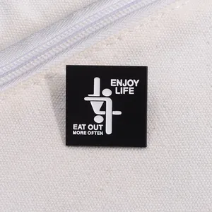 Close-up of a square enamel pin with 'ENJOY LIFE' text on a white canvas background