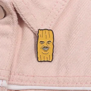 Épingle en émail jaune drôle avec motif meme sur un col de veste en jean rose