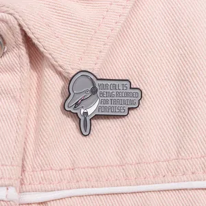 Detailed close-up of a corporate dolphin enamel pin on pink denim fabric texture