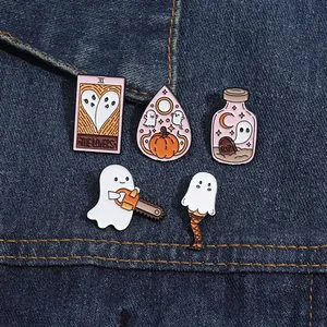 Détail macro de pin's en émail d'Halloween avec motifs tarot et fantômes sur du denim