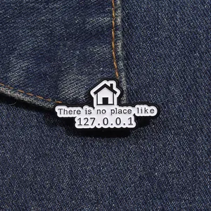 Macro detail of enamel geek brooch with There is no place like 127.0.0.1 on denim
