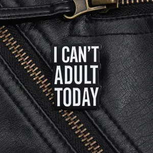 Macro shot of black enamel lapel pin with I CAN'T ADULT TODAY text on a leather jacket