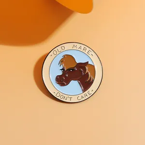 Detailed macro view of a circular Old Mare Don't Care enamel pin badge on orange background