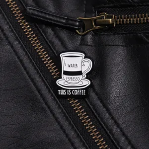 Détail macro d'un pin's émaillé café au design noir et blanc sur une veste en cuir
