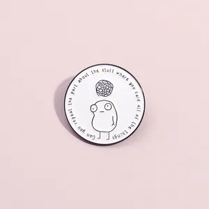 Funny enamel pin with cartoon face and quote on a soft pink background