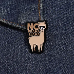 Détail d'une broche lama en émail avec lunettes sur un tissu en jean bleu