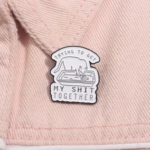 Badge en émail chat rigolo avec texte humoristique fixé sur une veste en jean tendance