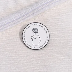 Detail of round enamel lapel pin with minimalist cartoon eye on canvas fabric