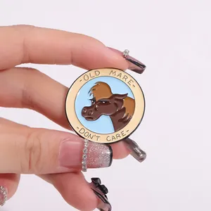 Detailed macro shot of a round enamel horse badge with Old Mare Don't Care slogan