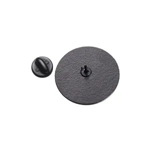 Detail view of round black metal brooch back with sandblasted texture and butterfly clutch