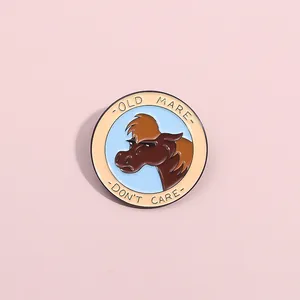 Cartoon horse enamel pin with Old Mare Don't Care slogan on pink background