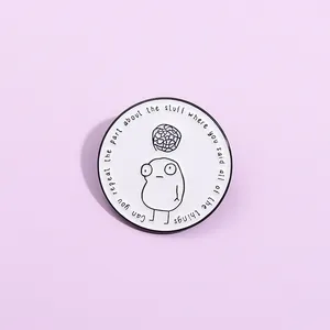 Minimalist enamel lapel pin featuring a white circular design with black cartoon artwork