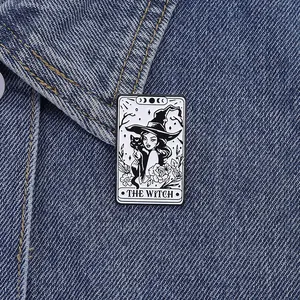 Gros plan d'un pin's tarot de sorcière avec chat noir sur une veste en jean bleue