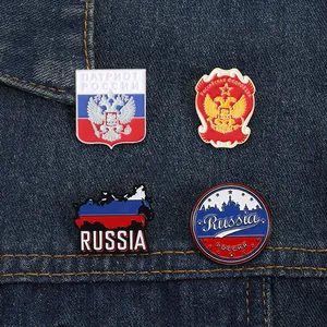 Set of four Russian eagle and flag themed enamel metal pins on denim background