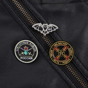 Macro shot of punk bat pins and military badges on black leather jacket zipper