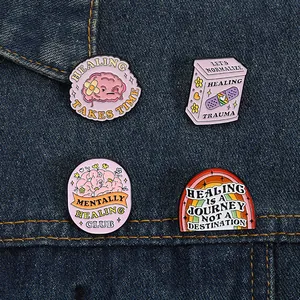 Macro detail of four mental health enamel pins pinned on a dark blue denim jacket texture