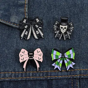 Close-up of four Gothic Halloween enamel pins featuring skulls and ghosts on denim