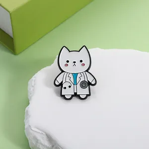 Detail of cute white cat doctor enamel pin with stethoscope on a textured stone stand