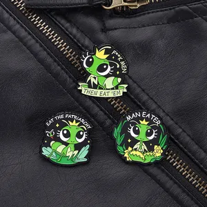 Detail of green praying mantis enamel pins on a black leather jacket with satirical text
