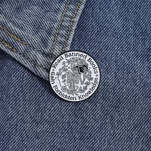 Detailed close-up of a Read Banned Books skull pin on blue denim fabric background