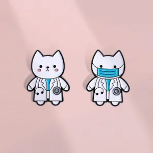 Set of two cute white cat doctor enamel pins with stethoscopes on soft pink background