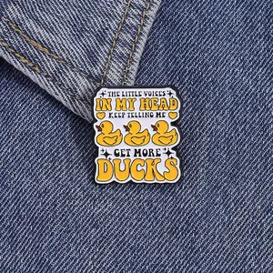 Funny little ducks enamel pin with creative text on dark blue denim jacket