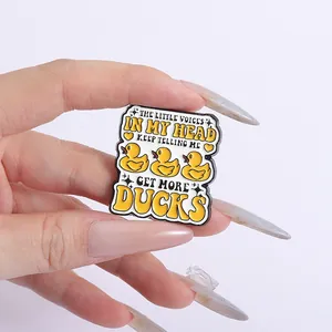 Funny yellow duck enamel pin badge with creative quote held against white background