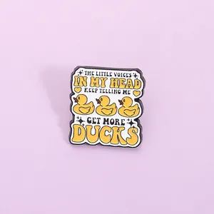 Close-up of funny yellow duck enamel pin with humorous text get more ducks quote