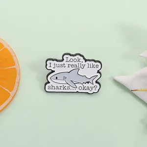 Detail of shark enamel pin with humor quote on a soft green background decor