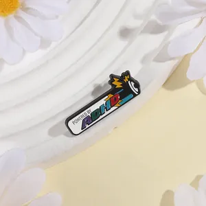 Macro shot of colorful battery enamel pin showing POWERED BY ADHD text detail