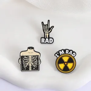 Détails de trois épinglettes en émail sur la radiologie avec main squelette et signe de radiation