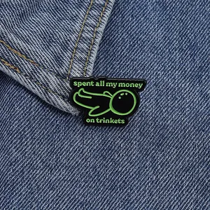Gros plan d'un pin's en émail avec texte humoristique sur un col en jean bleu