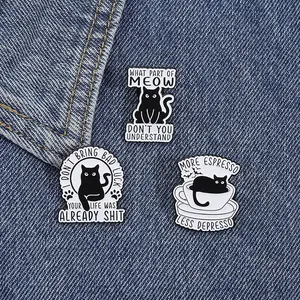 Detailed view of three black cat enamel pins on denim, featuring funny English slogans