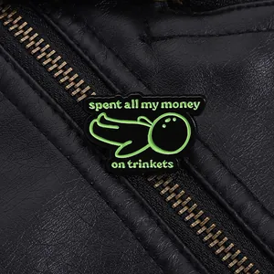 Détail macro d'une broche en émail avec texte humoristique sur une veste en cuir noir