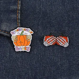 Funny Halloween enamel pins set featuring pumpkin motifs held by skeletal hands on denim