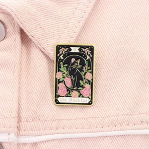 Macro shot of The Black Cat tarot style enamel pin with pink roses on a denim jacket