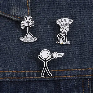 Three enamel stickman pins on denim: graphic designer, me and friends, and yelling man